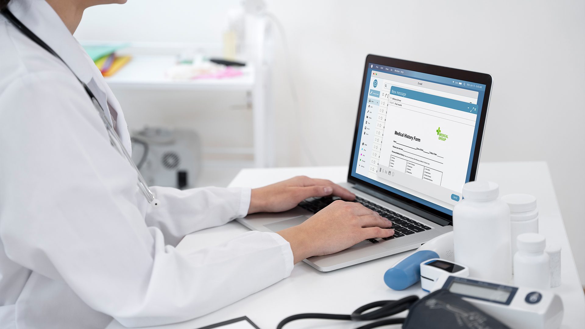 A doctor is focused on a laptop computer, likely reviewing patient information or conducting research.